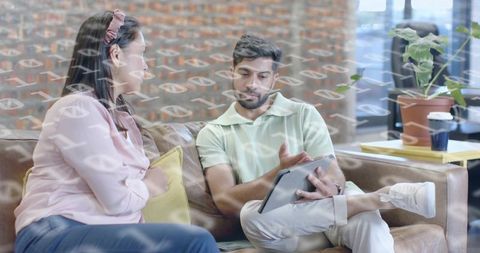 Colleagues Collaborating with Tablet in Modern Office Lounge
