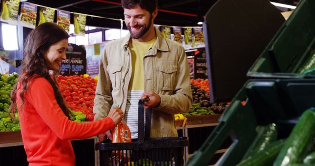 Couple enjoying grocery shopping at a supermarket's produce section. They are selecting fresh vegetables while smiling and conversing. This image is suitable for promoting healthy eating, shopping experiences, and advertising supermarket or market products.