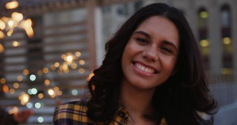 Joyful Young Woman Holding Sparkler at Rooftop Party