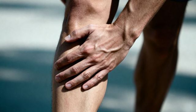 Runner Grasping Knee While Running Showing Leg Pain and Muscle Strain with Visible Veins