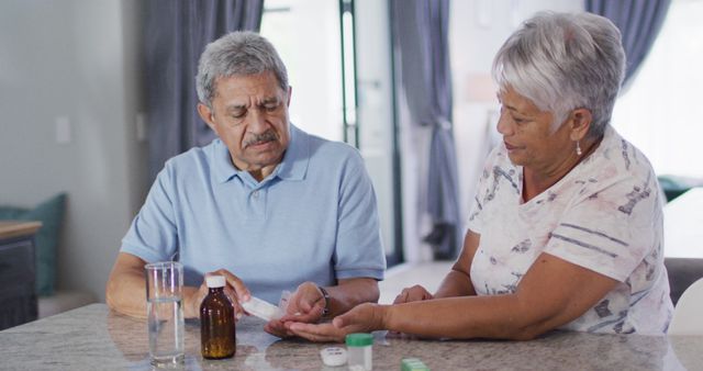 Senior biracial couple talking and taking pills. Spending quality time at home, retirement and lifestyle concept.