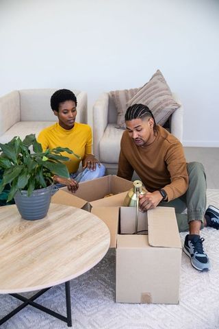 Couple Unpacking Lamp in Modern Living Room Interior