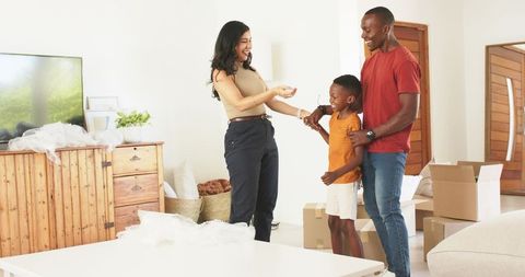 Family receiving house keys during move-in, parents helping son unpack and celebrate