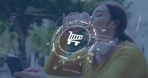 Woman drinking coffee and using smartphone for mobile shopping with futuristic cart hud overlay