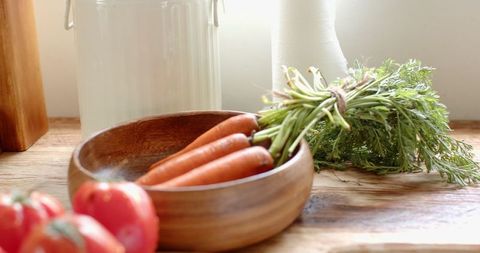 Fresh Carrots with Greens on Rustic Kitchen Counter