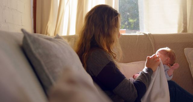 Caring Mother Holding Newborn in Sunlit Living Room - Download Free Stock Images Pikwizard.com