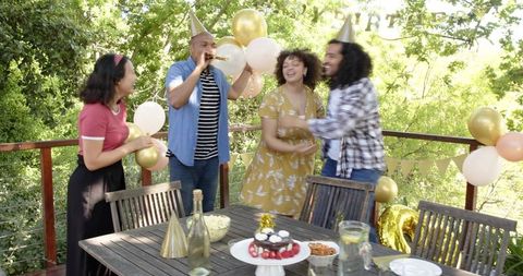 Friends Celebrating Birthday Outdoors with Festive Atmosphere