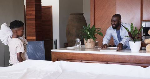 African American Father and Son Sharing Morning Smile and Bond in Cozy Kitchen