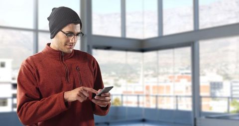 Man in beanie using smartphone in contemporary office space