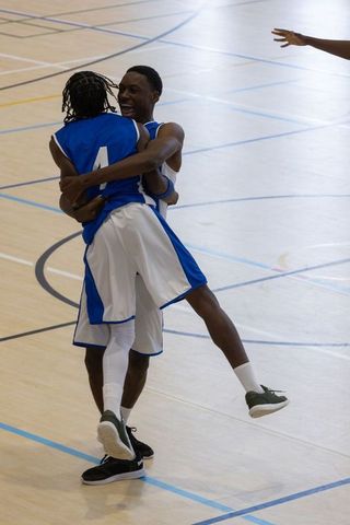 Basketball Players Celebrating Victory on Indoor Court