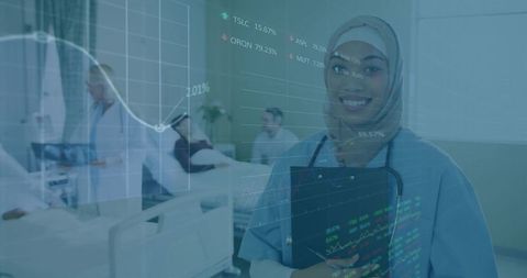 Smiling nurse with headscarf analyzing medical data in hospital ward