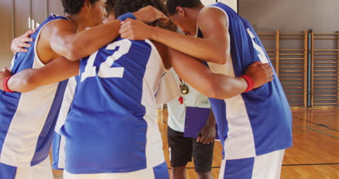 Diverse Basketball Team Huddling with Coach for Strategy
