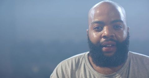 Bearded african american man sweating and recovering after workout, wearing grey t-shirt