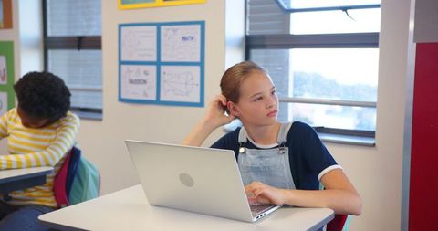 Diverse schoolmates engaging with technology in classroom setting