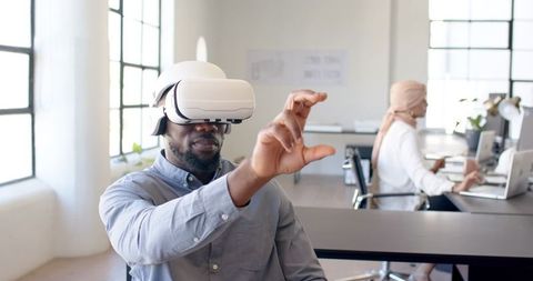 Businessman Using VR Headset for Virtual Interaction in Office