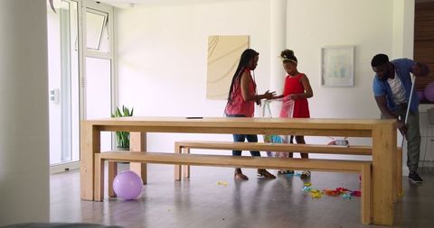 Family Tidying Festive Mess Together at Modern Home