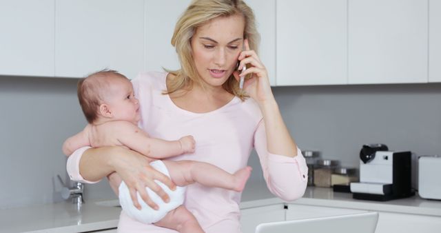 Busy Mother Multitasking with Baby While on Phone in Kitchen - Download Free Stock Images Pikwizard.com