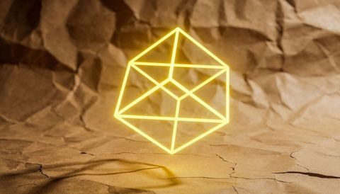 Glowing yellow wireframe polyhedron floating over crumpled kraft paper casting soft shadow