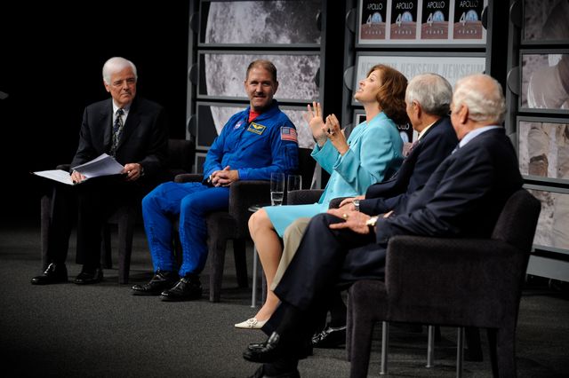 Group of notable figures from the Apollo missions and other space endeavors participating in a panel discussion commemorating the 40th anniversary of the Apollo 11 moon landing. Use for articles or features on historic space events, anniversaries, or key presentations in space exploration history.