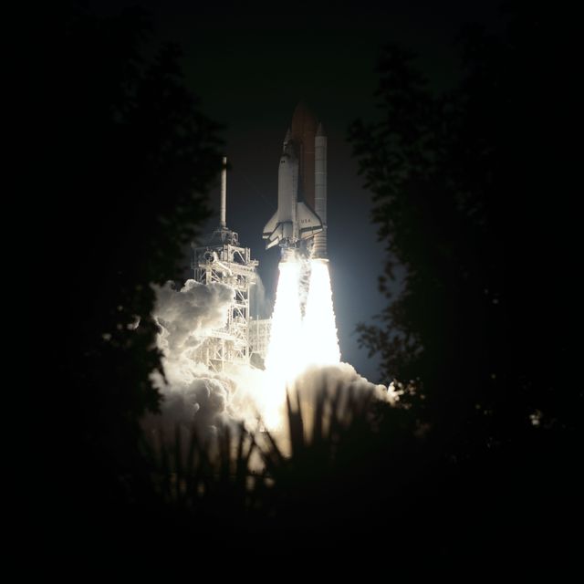STS93-S-007 (23 July 1999) --- Framed by Florida foliage in this night time scene, the Space Shuttle Columbia lifts off from Launch Pad 39B to begin the five-day STS-93 mission.  After two unsuccessful attempts earlier in the week, liftoff occurred at 12:31 a.m. (EDT), July 23, 1999.  Only hours after this picture was taken, the five-member crew released the Chandra X-Ray Observatory into orbit.  Onboard were astronauts Eileen M. Collins, first woman shuttle commander; Jeffrey S. Ashby, pilot; and Steven A. Hawley, Catherine G. Coleman and Michel Tognini, all mission specialists.  Tognini represents the Centre National d'Etudes Spatiales (CNES) of France.