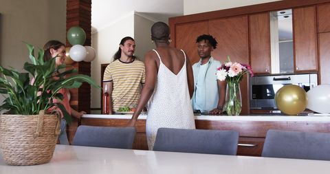 Friends Socializing in Modern Kitchen During Casual Gathering