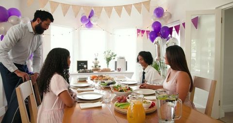 Multiracial family celebrating with elegant decor and food spread