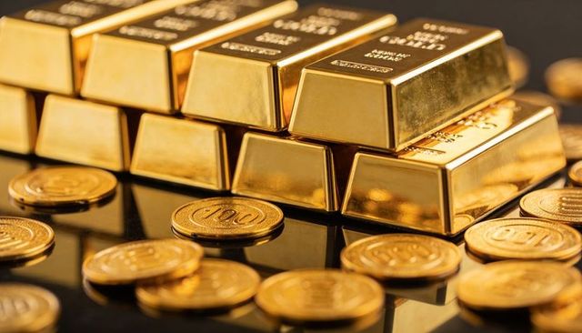 Glinting gold bullion bars and coins on glossy black surface for investment