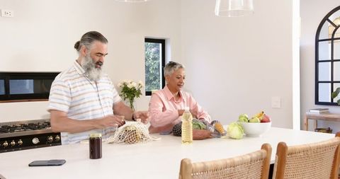 Senior Couple Preparing Groceries in Modern Kitchen