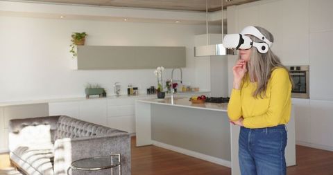 Senior Woman Engaging with Virtual Reality in Modern Kitchen