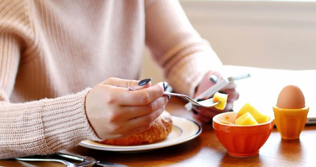 Woman using mobile phone while having breakfast at home - Download Free Stock Photos Pikwizard.com