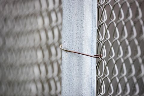 Close-up of chain-link fence with steel wire