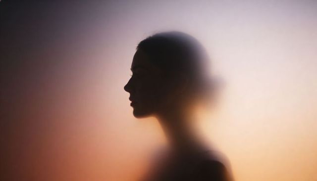 Backlit female profile silhouette with halo glow and soft ombre gradient
