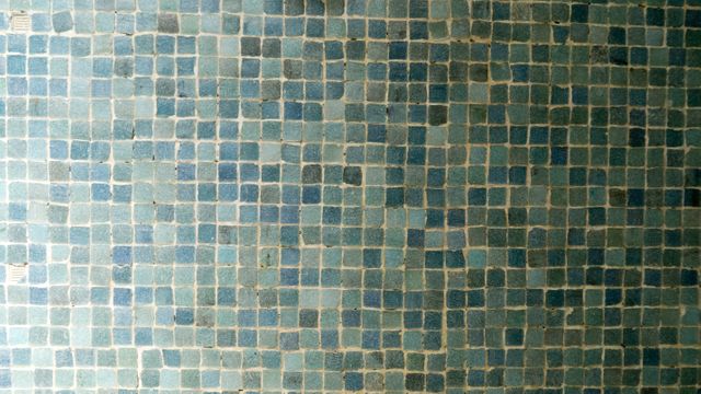 Close-up of blue ceramic mosaic tile wall showing intricate pattern and grid. Ideal for use in interior design presentations, architectural projects, website backgrounds, texture references, and home decor inspiration.