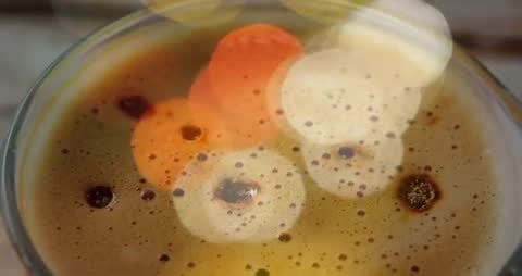 Overhead espresso cup showing drifting warm bokeh and rich crema in slow motion