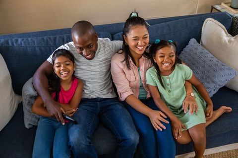 Joyful Family Relaxing on Cozy Sofa Holding Remote