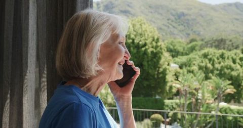 Senior Woman Enjoying Comfortable Smartphone Chat on Scenic Terrace