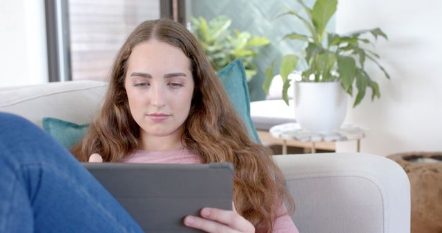 Young Woman Relaxing on Sofa Using Digital Tablet at Home - Download Free Stock Images Pikwizard.com