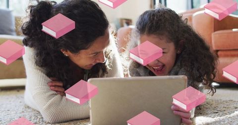 Mother and daughter joyfully using digital tablet with book icons overlay