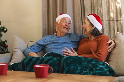Senior couple enjoying christmas togetherness on cozy sofa