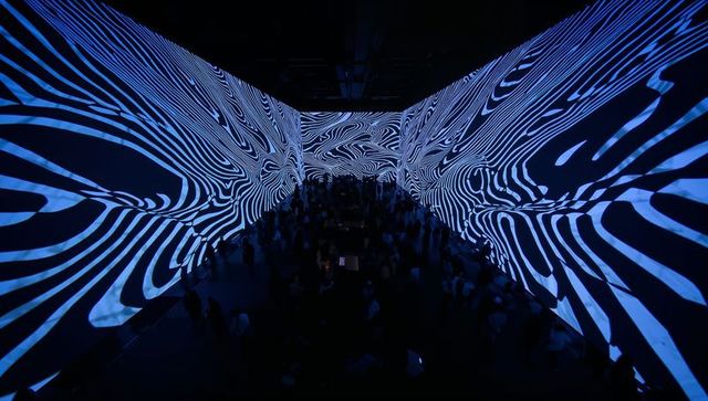 Immersive blue-white projection mapping with abstract stripes engulfing exhibition space