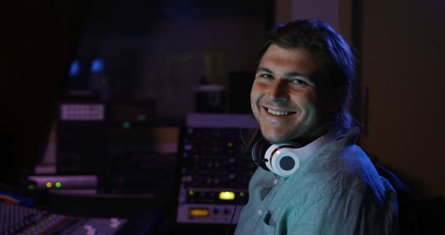 Music Producer Smiling in Recording Studio with Headphones Around Neck - Download Free Stock Images Pikwizard.com