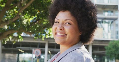 Confident Plus Size Woman Smiling Outdoors in Urban Environment