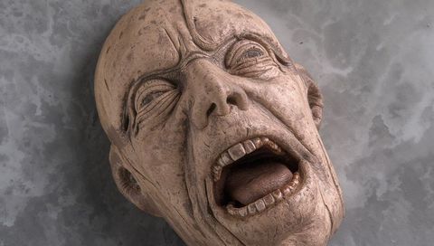 Sculpted screaming head weathered patina close-up for horror prop and art study