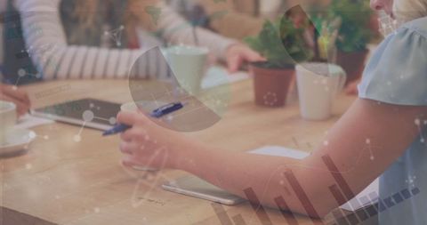 Businesswoman writes financial reports in office with data overlay