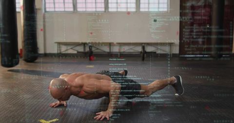 Muscular man performing push-up with digital code overlay in industrial gym