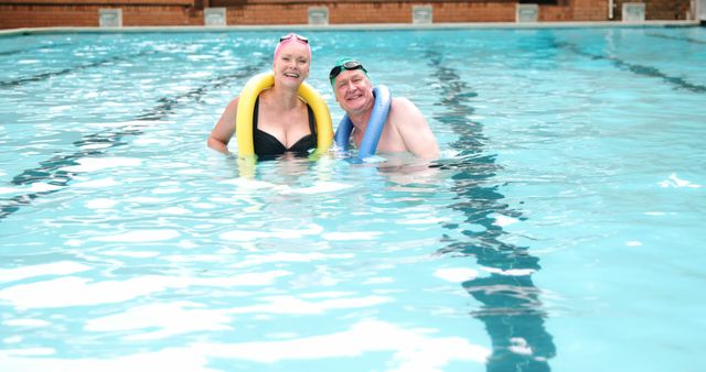 A middle-aged Caucasian couple enjoys leisure time in a swimming pool, with copy space - Download Free Stock Photos Pikwizard.com