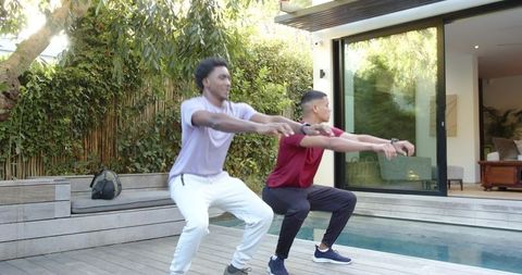 Diverse Friends Exercising Together on Modern Poolside Deck