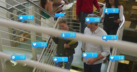 Colleagues walking down office staircase showing rising social media engagement alerts