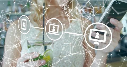 Woman checking smartphone while holding lime drink in café with digital network overlay
