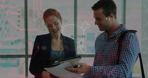 Business colleagues reviewing documents and tablet with cybersecurity overlay in glass office